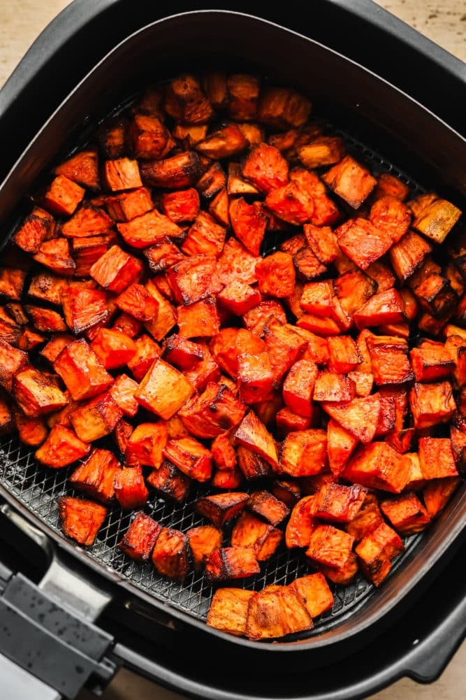 blackened and golden air fryer sweet potatoes in the basket.