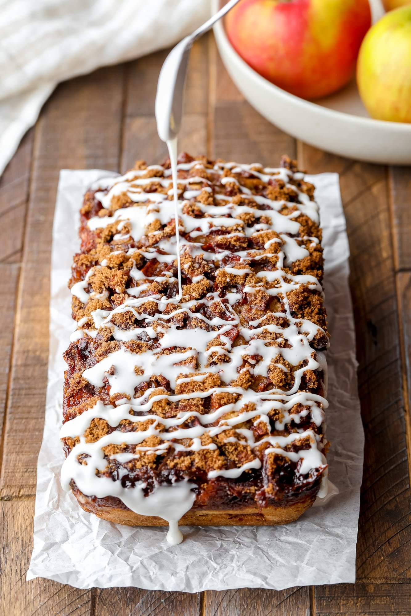 Drizzling a thin, white icing over a dessert loaf.