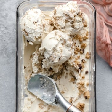 looking down on several scoops of cookie dough ice cream on grey backdrop with pink lacy towel.