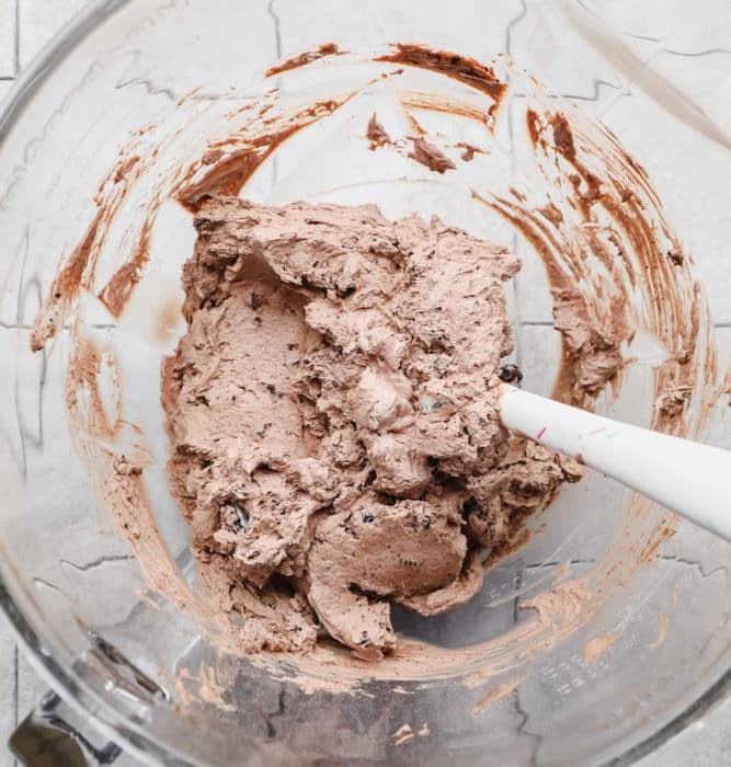 chocolate whipped frosting in a bowl with spatula.