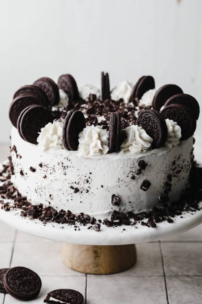 whole oreo cake with white frosting and lots of cookies on top.