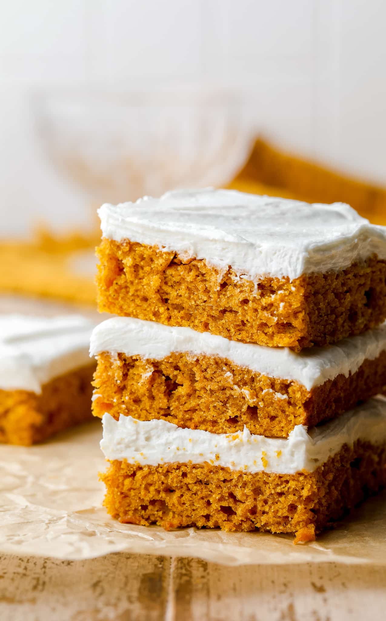 3 vegan pumpkin cake bars stacked on top of each other.