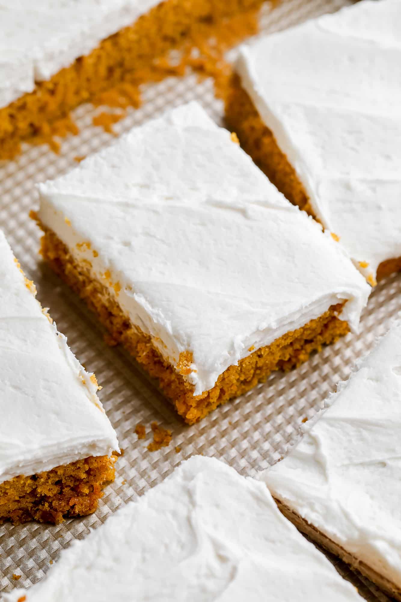 overhead view of vegan pumpkin cake bars with cream cheese frosting on top.