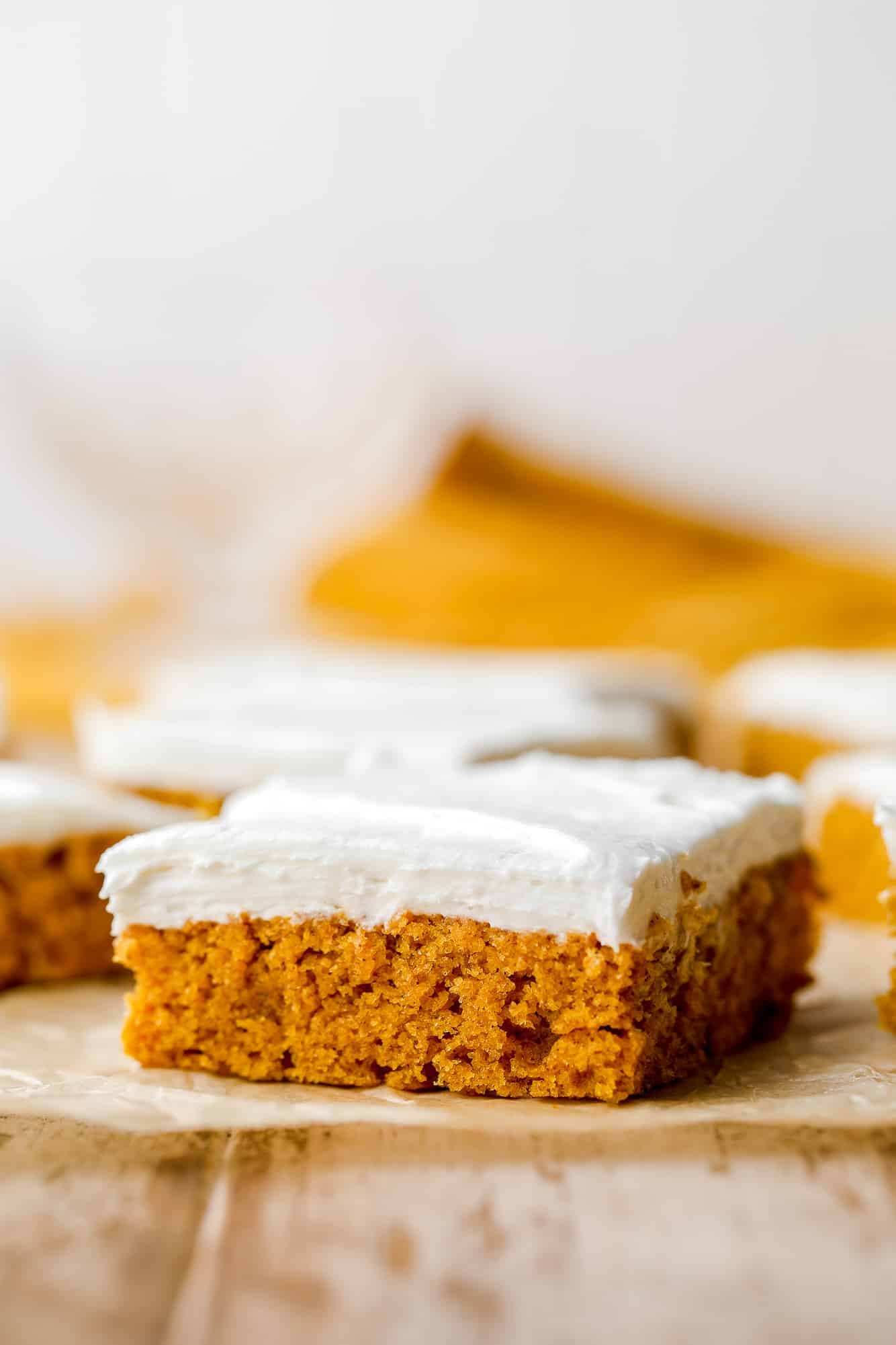 a vegan pumpkin cake bar with cream cheese frosting on top.