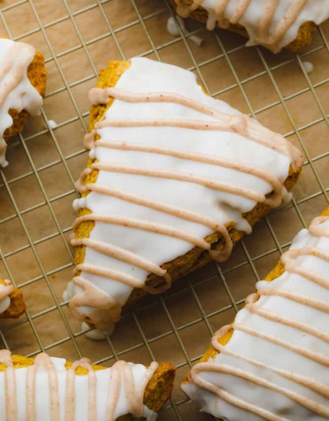 looking down on several scones that are orange with two glazes.