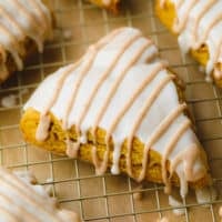 triangle scone with white and tan glaze on cooling rack.