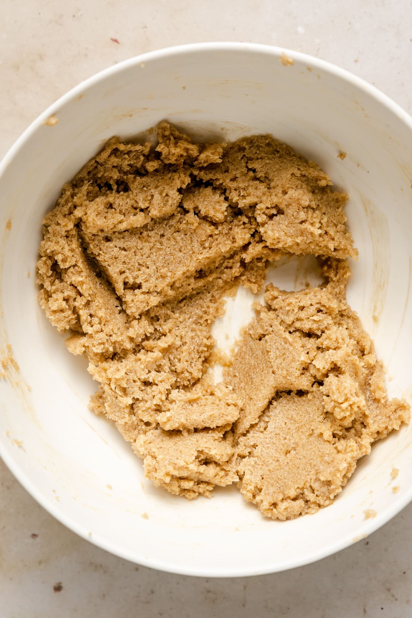 raw light brown cookie dough in a white bowl.