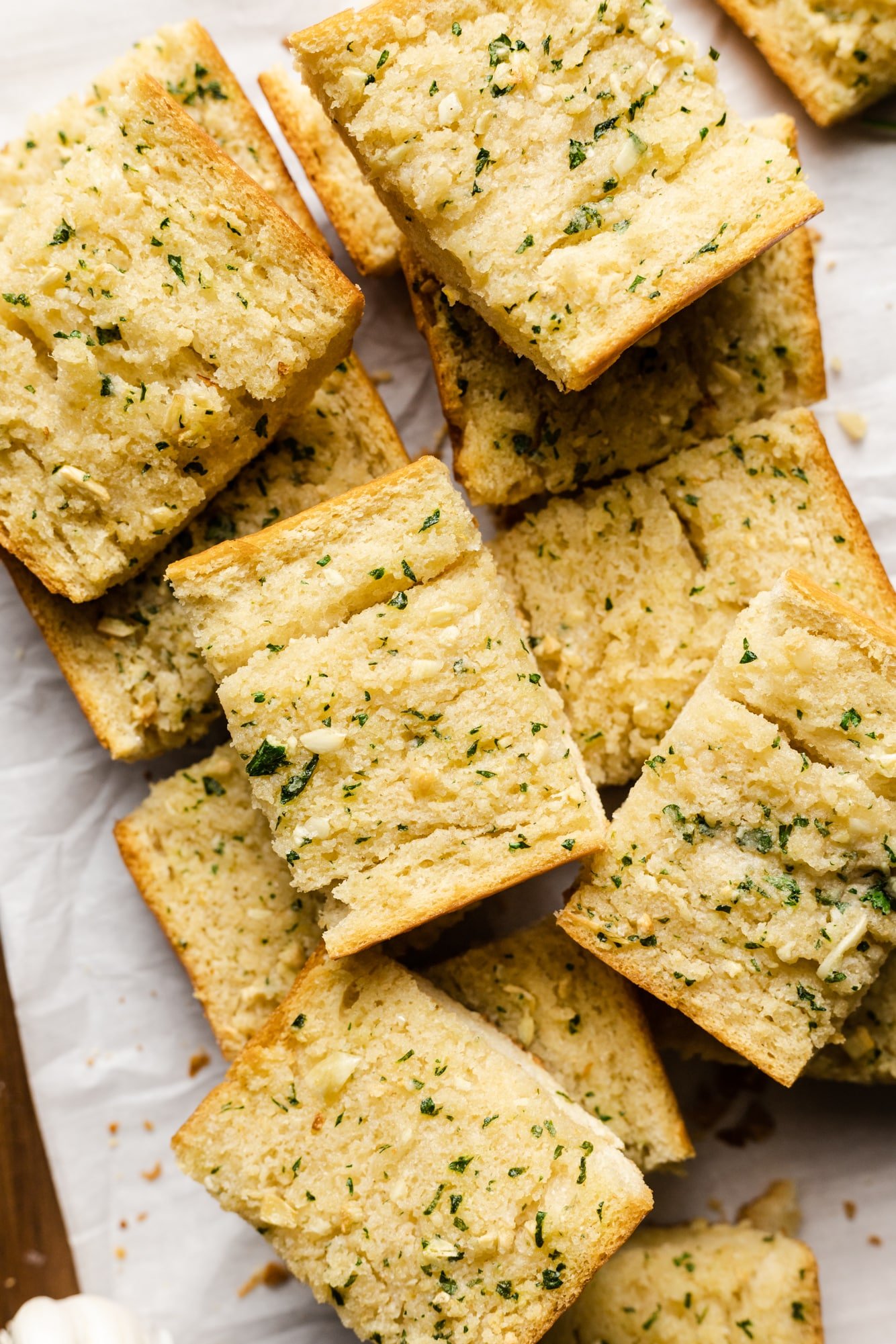 baked pieces of vegan garlic bread piled on top of each other.