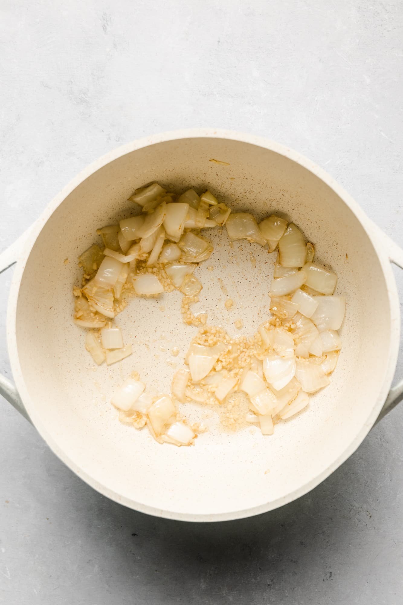 cooked onions and garlic in a white pot.