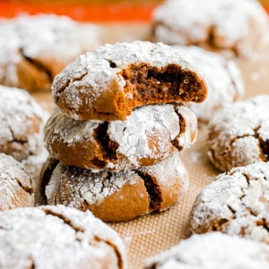 close up of a ginger crinkle cookie with a bite taken out on two other cookies