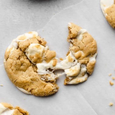 a fluffernutter cookie broken in half on parchment paper.