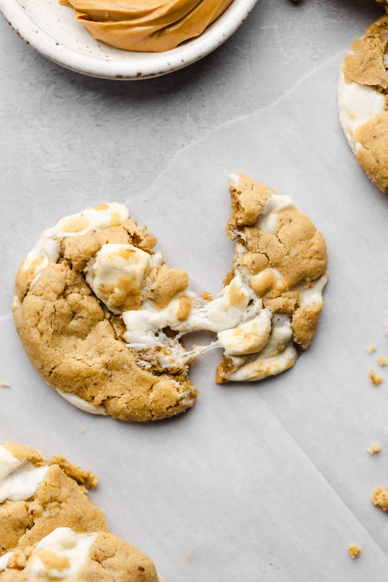 a fluffernutter cookie broken in half on parchment paper.