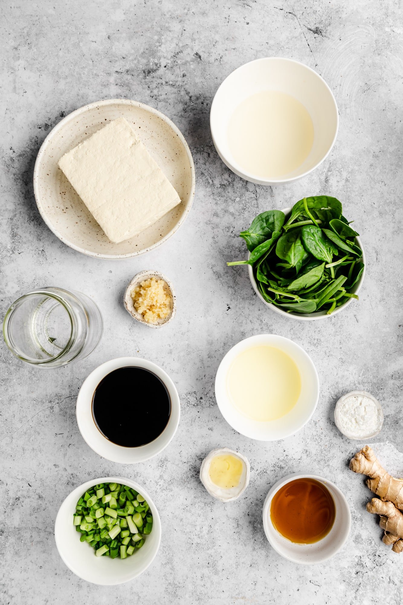 ingredients for tofu stir fry in individual white bowls.