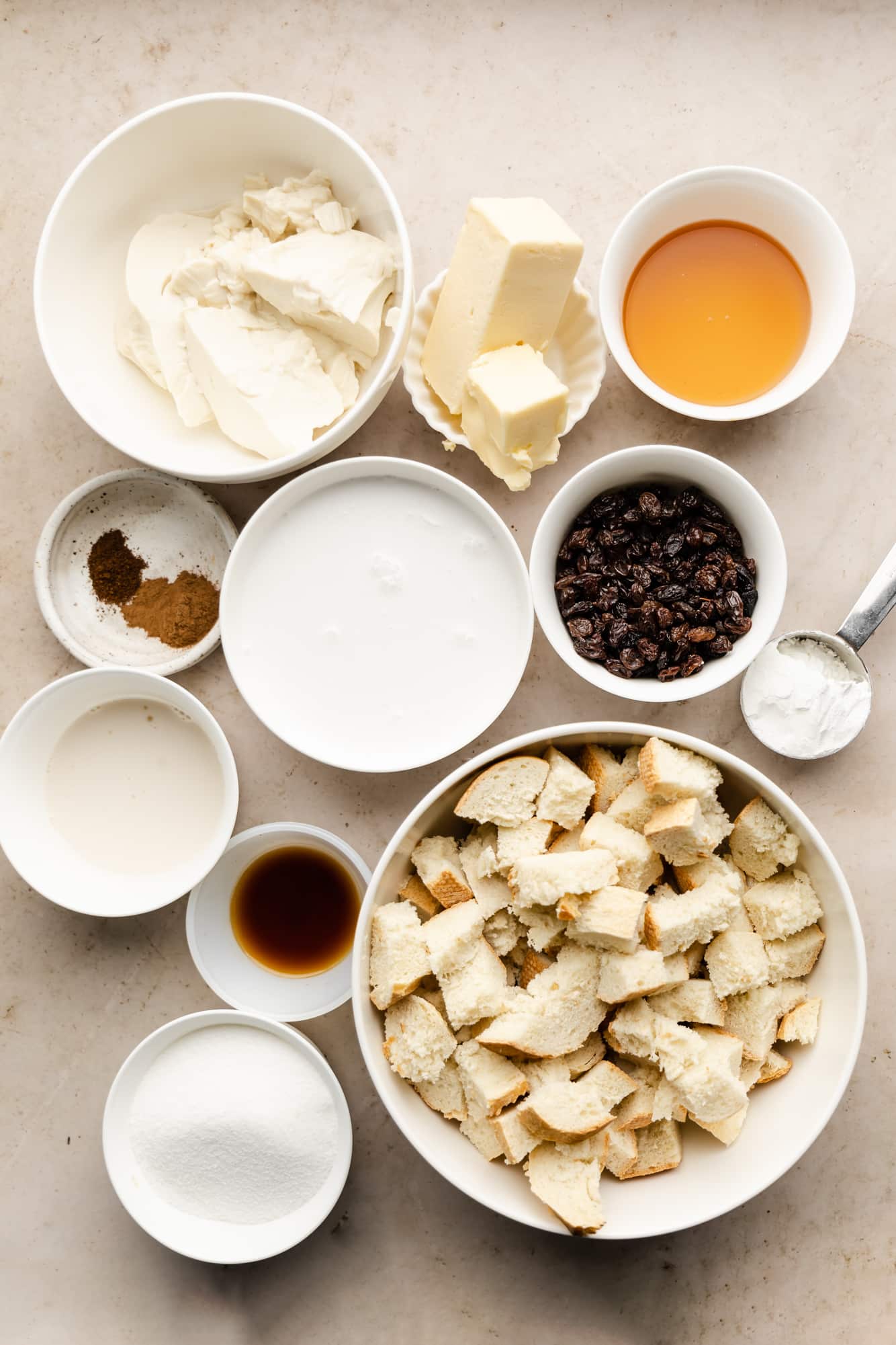 ingredients for vegan bread pudding in individual white bowls.