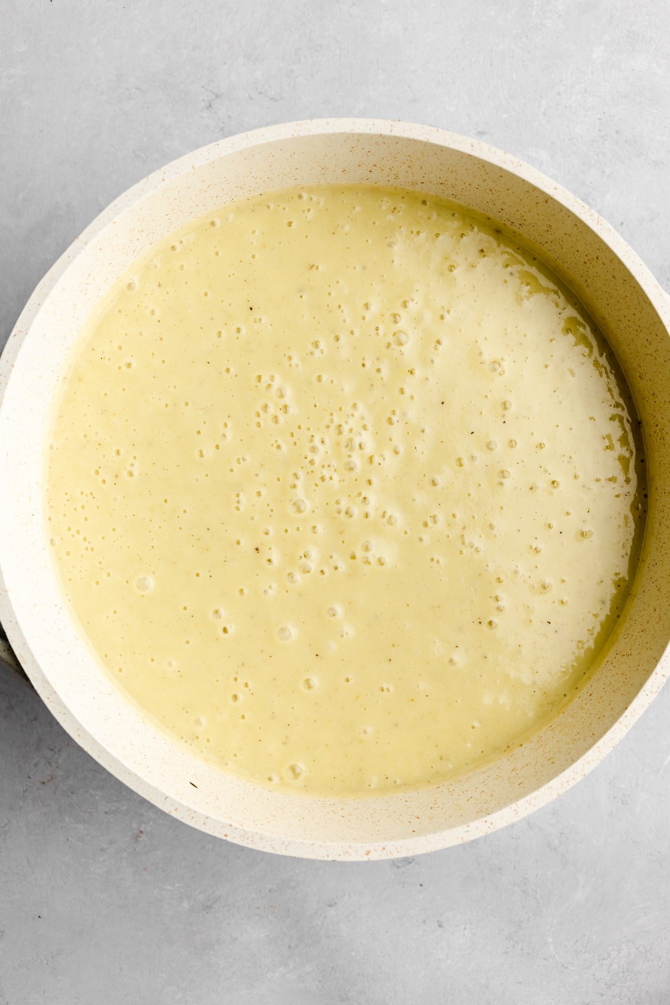 pureed vegan potato leek soup in a large white pot.