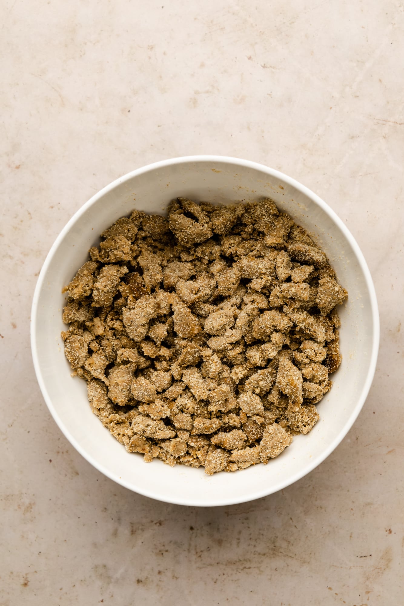 breadcrumb-coated vegan sausage crumbles in a white bowl.