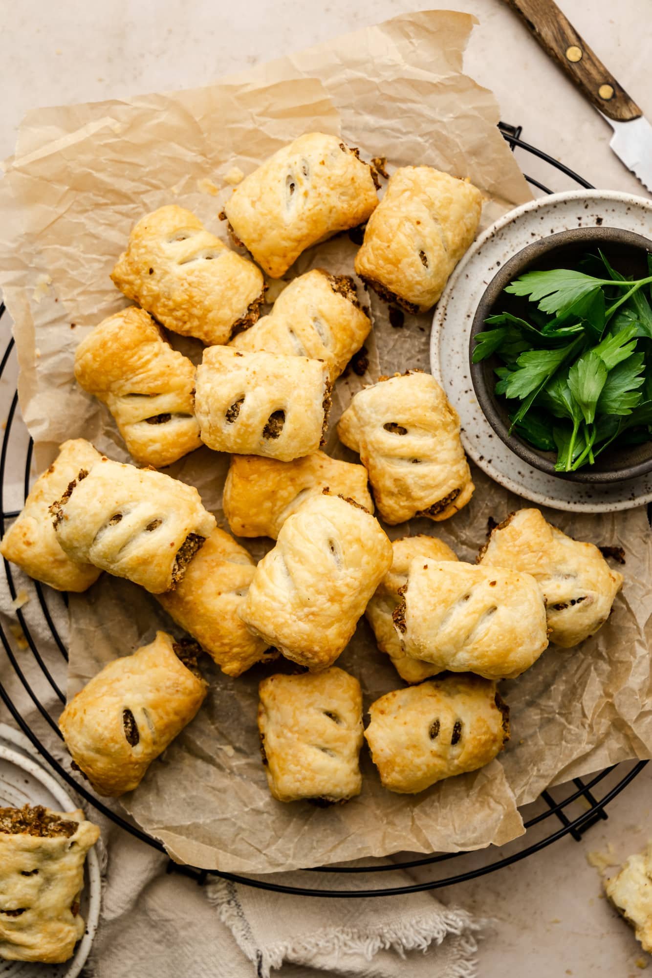 baked vegan sausage rolls on a parchment-lined serving platter.