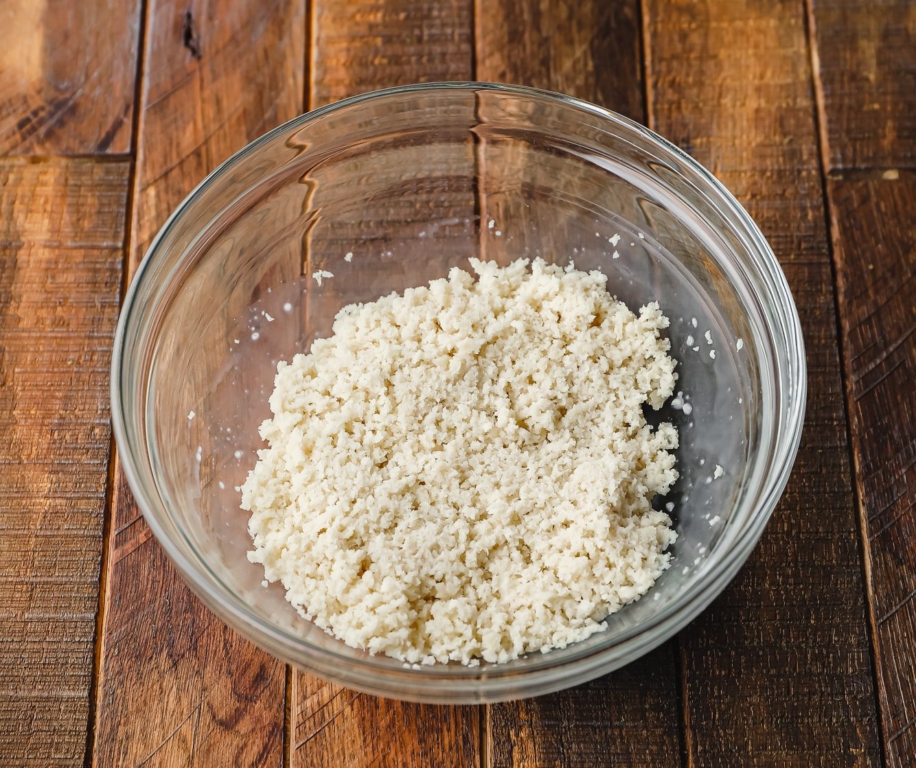 moistened panko breadcrumbs in a glass bowl.