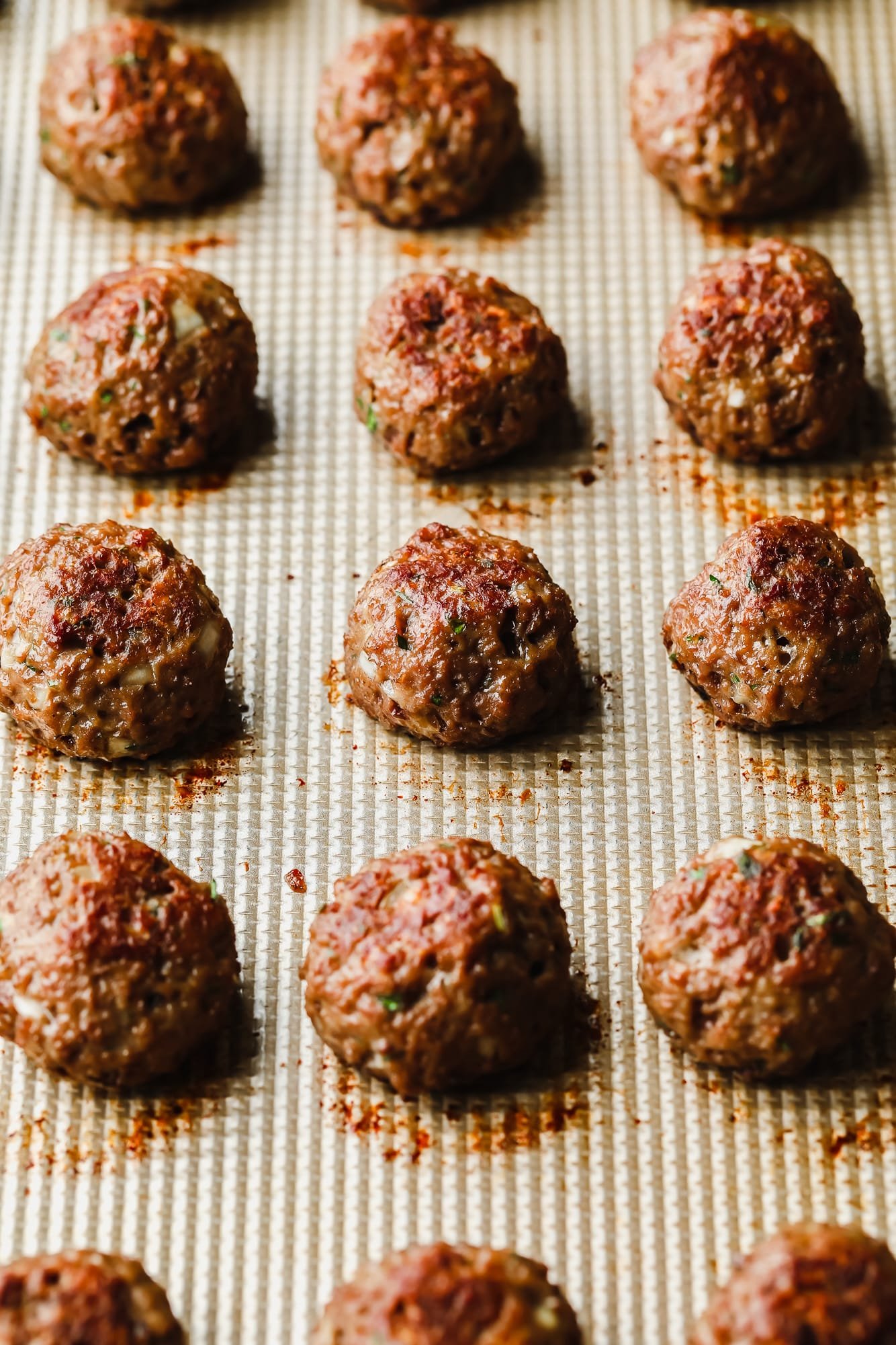 close up on rows of baked vegan meatballs on a baking sheet.
