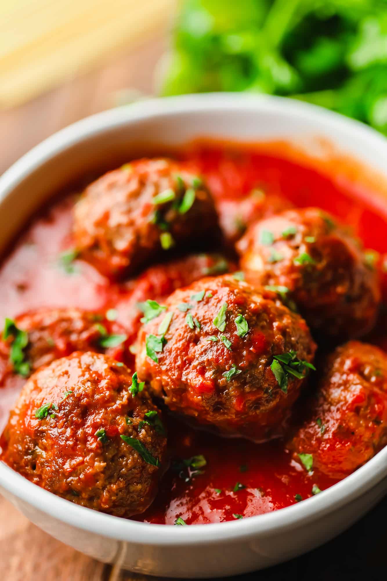 vegan meatballs covered in marinara sauce in a white bowl.