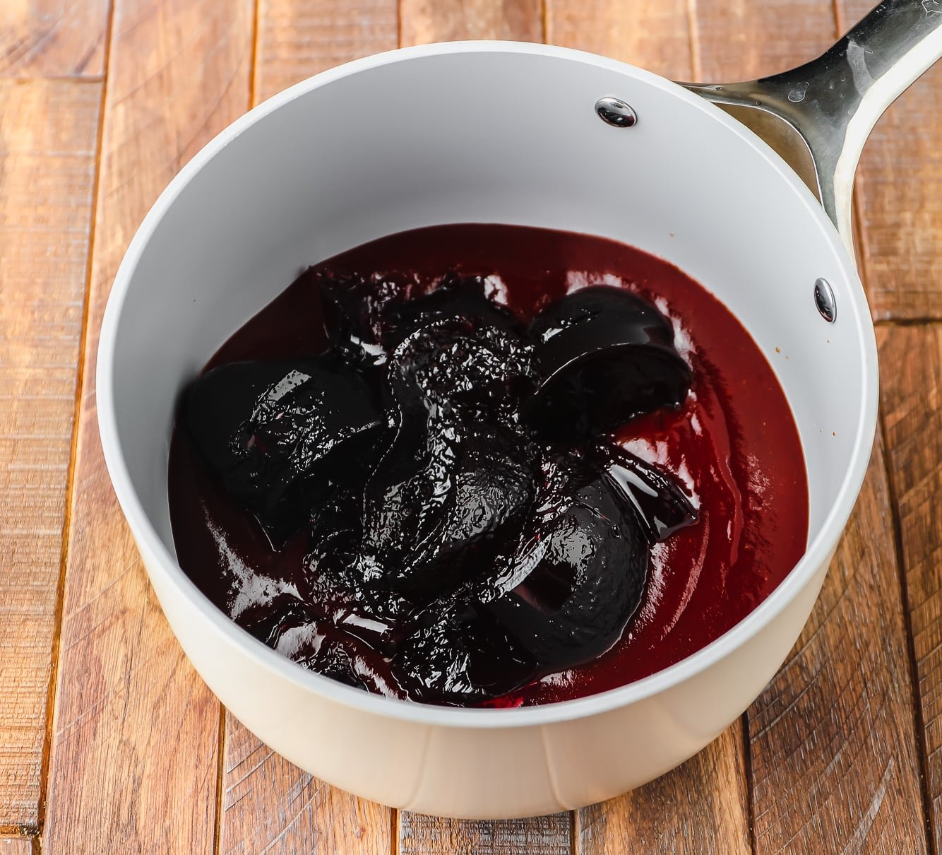BBQ sauce and grape jelly poured into a grey saucepan.