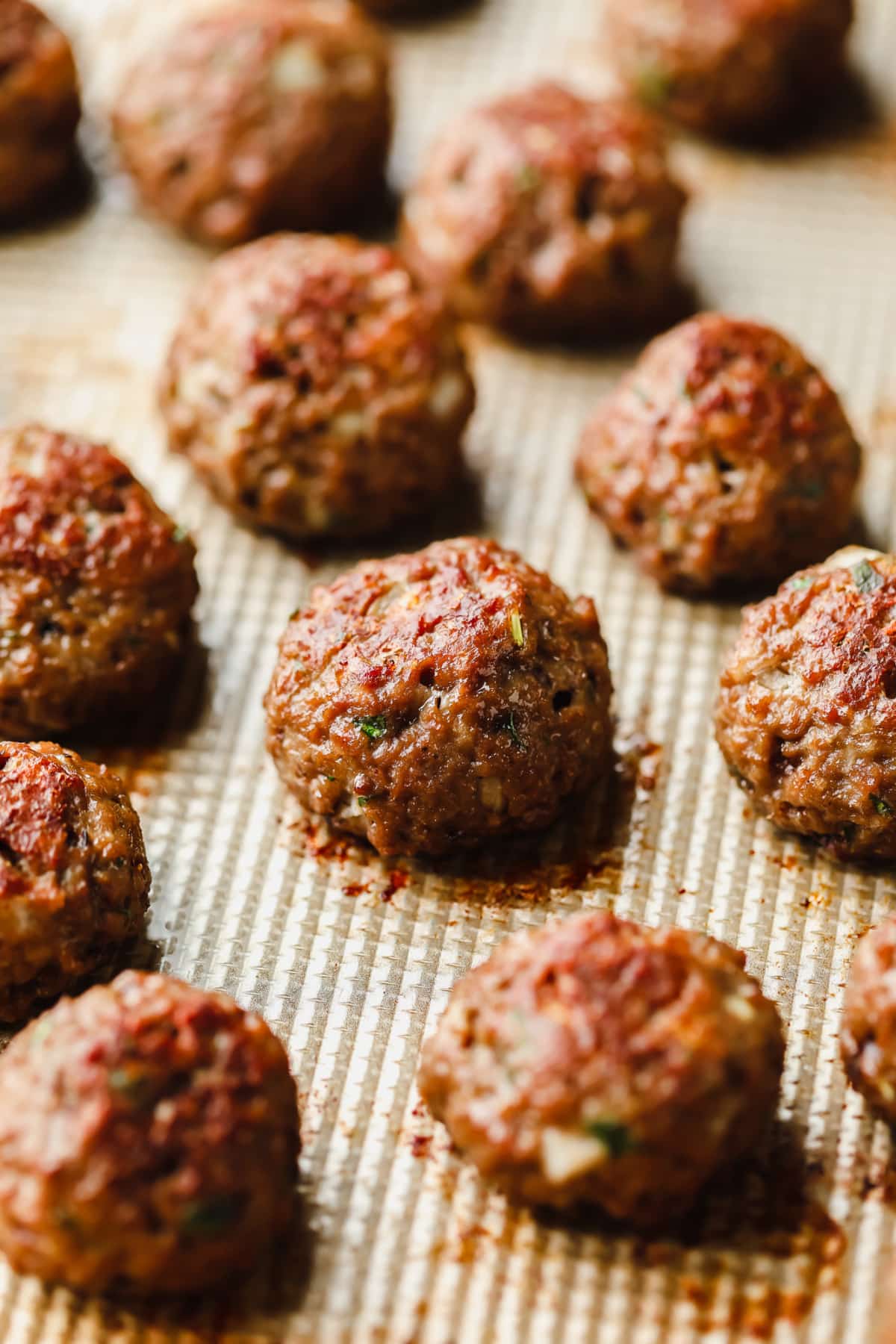 baked vegan meatballs in rows on a sheet pan.