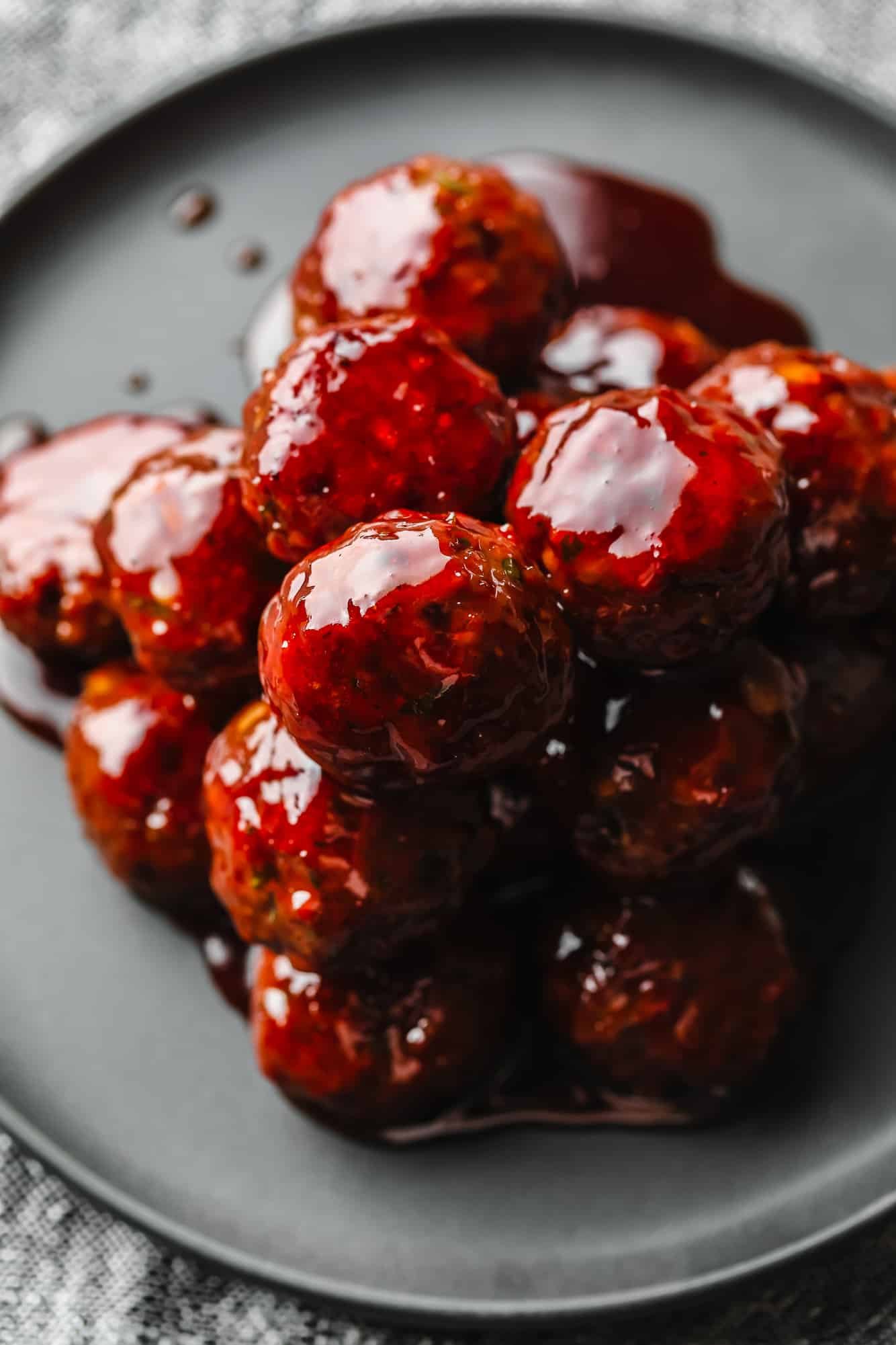 a pile of vegan grape jelly meatballs on a grey plate.
