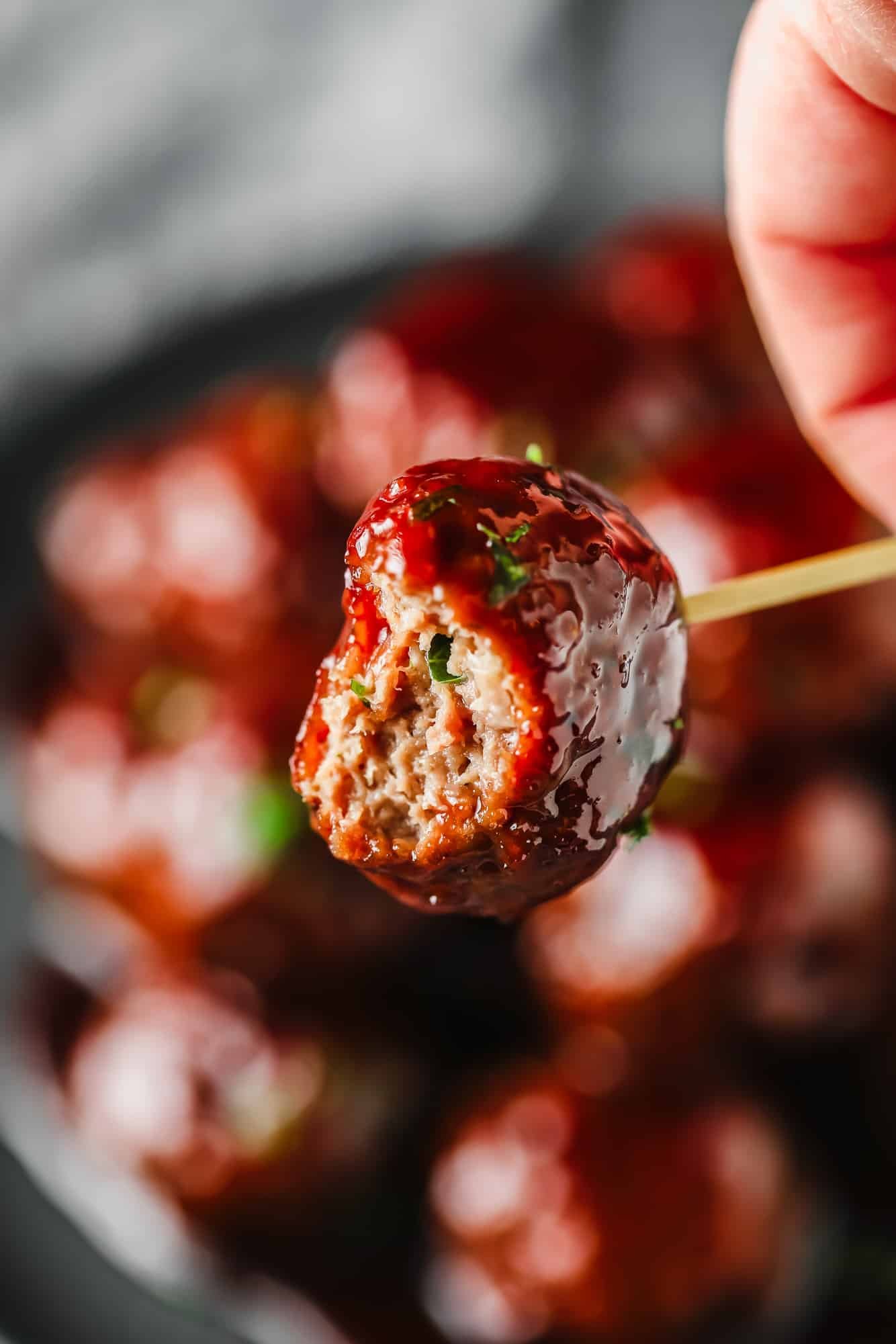 close up on a vegan grape jelly meatball with a bite taken out of it.