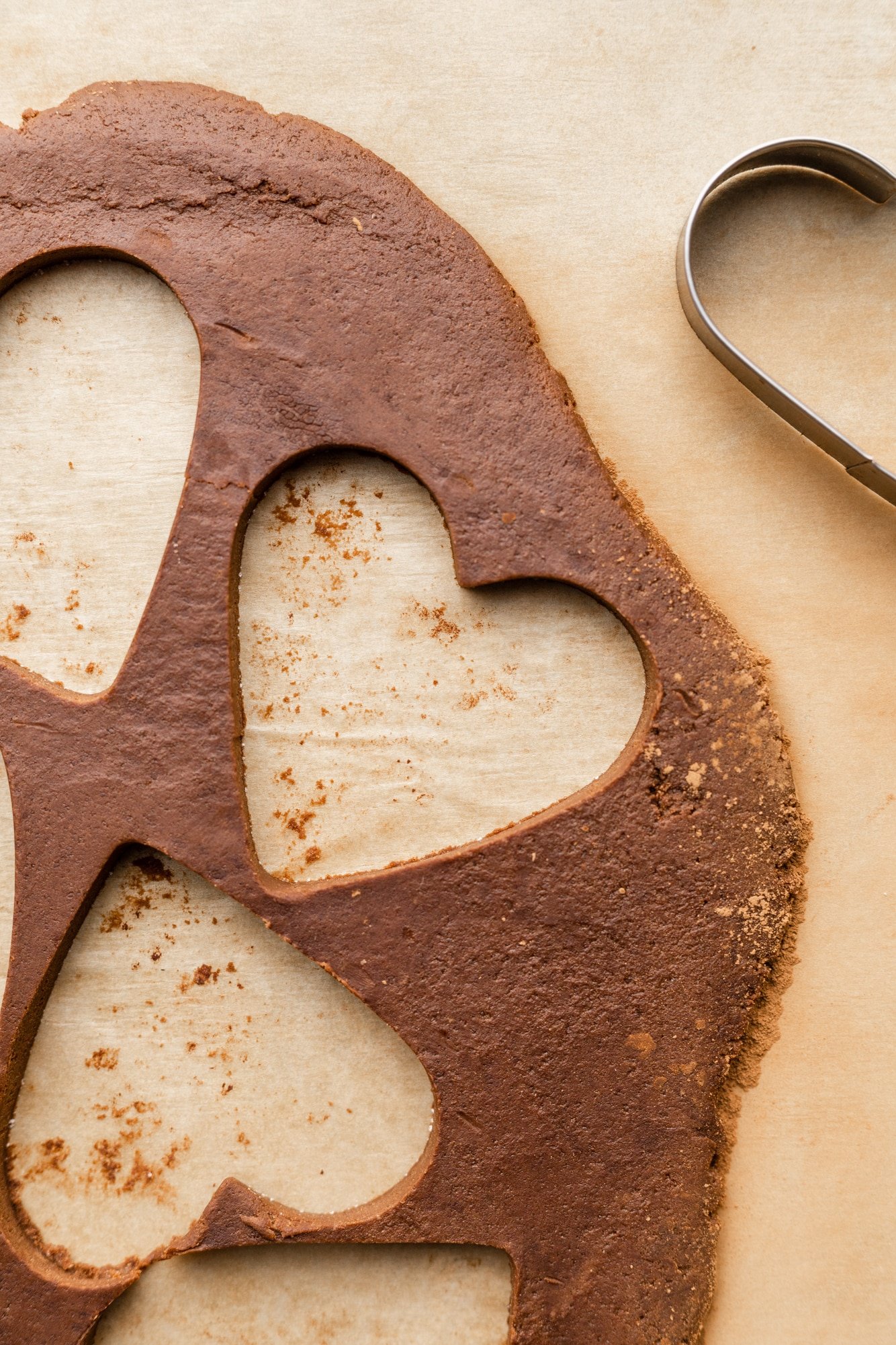 rolled out chocolate cookie dough with heart-shaped holes.