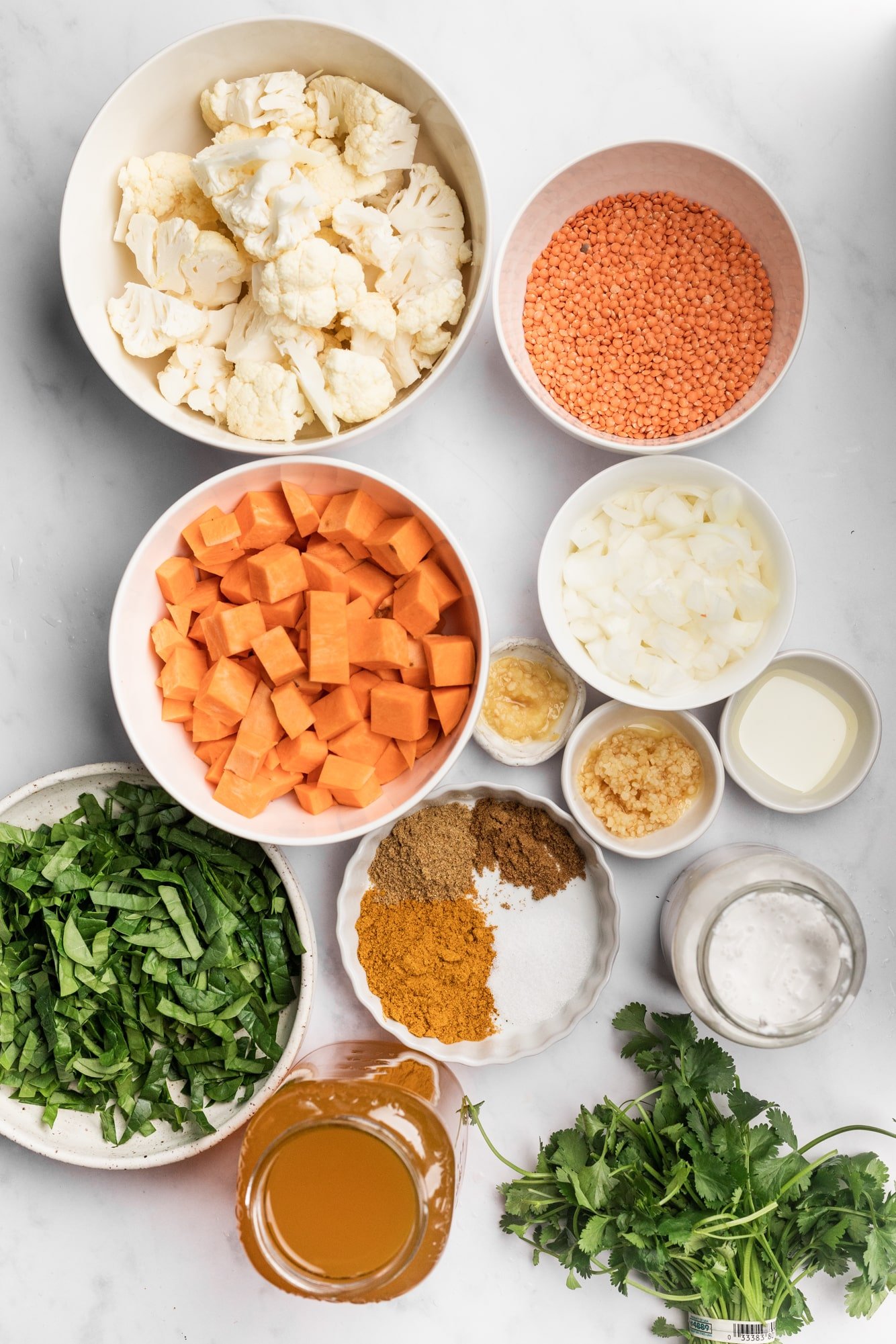 ingredients for coconut curry lentil soup in individual white bowls.