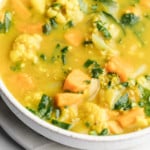 close up on coconut curry lentil soup in a large white bowl.