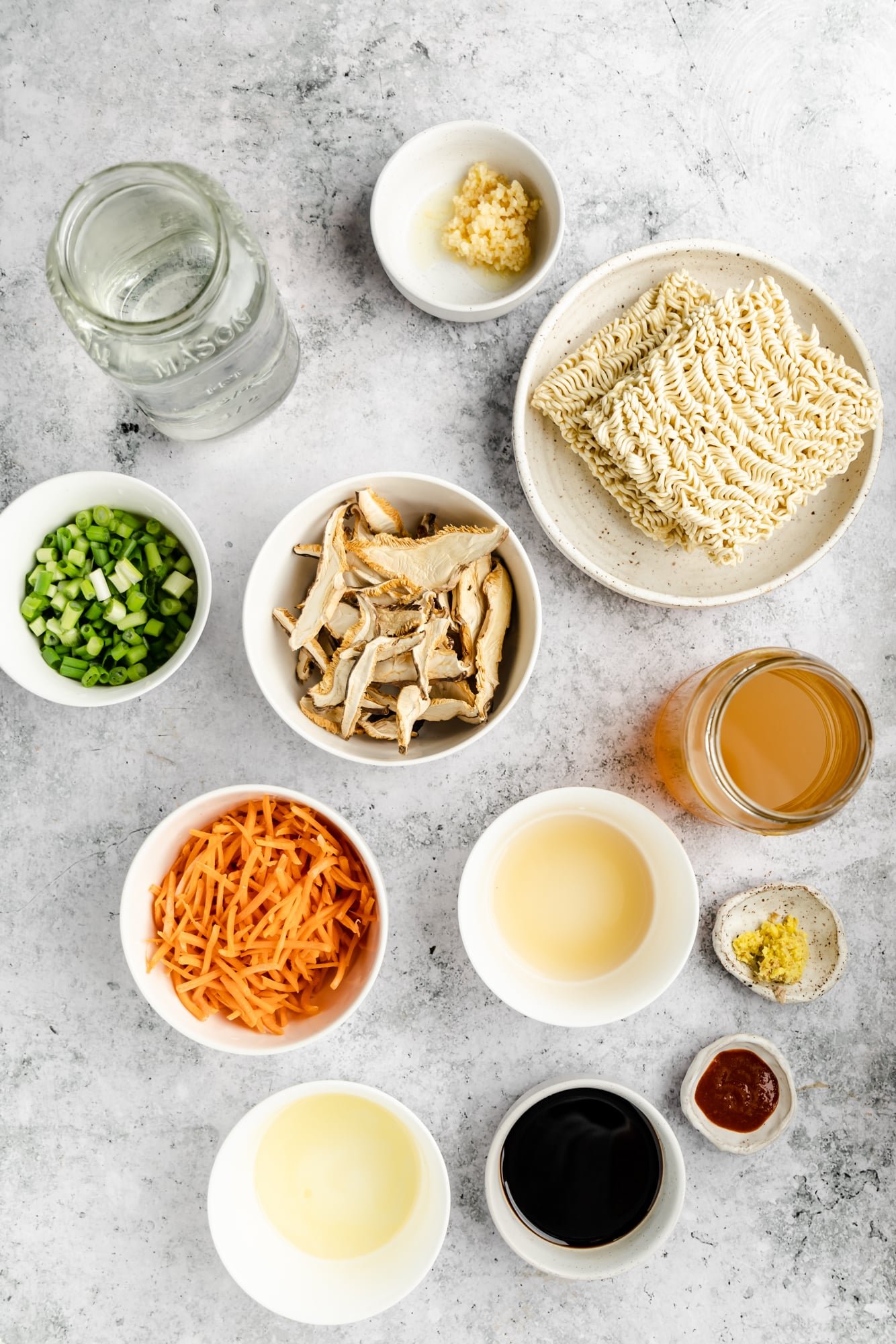 Simple vegan ramen ingredients in individual white bowls.