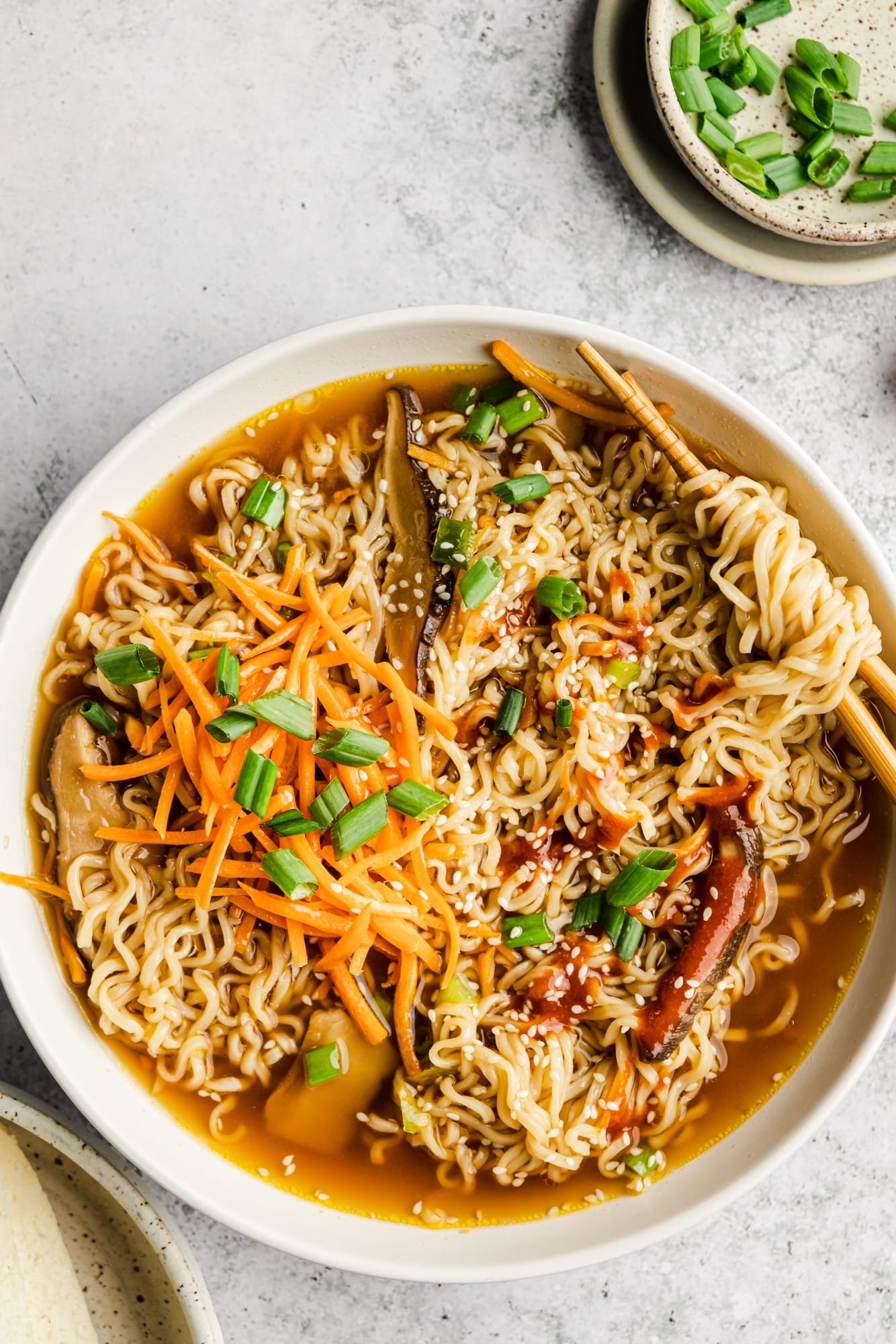 vegan ramen in a large white bowl with chopsticks.