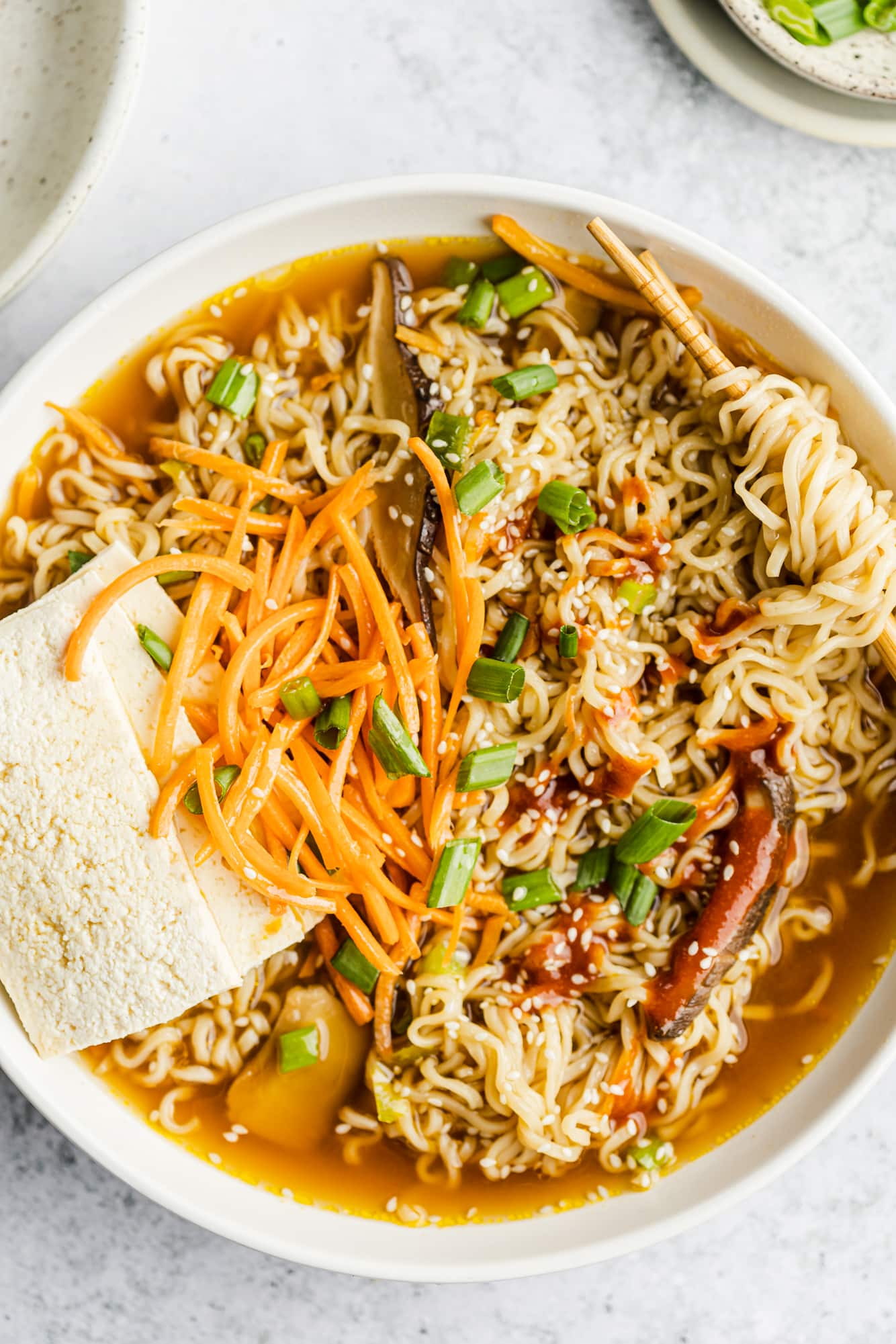 vegan ramen in a large white bowl with chopsticks.