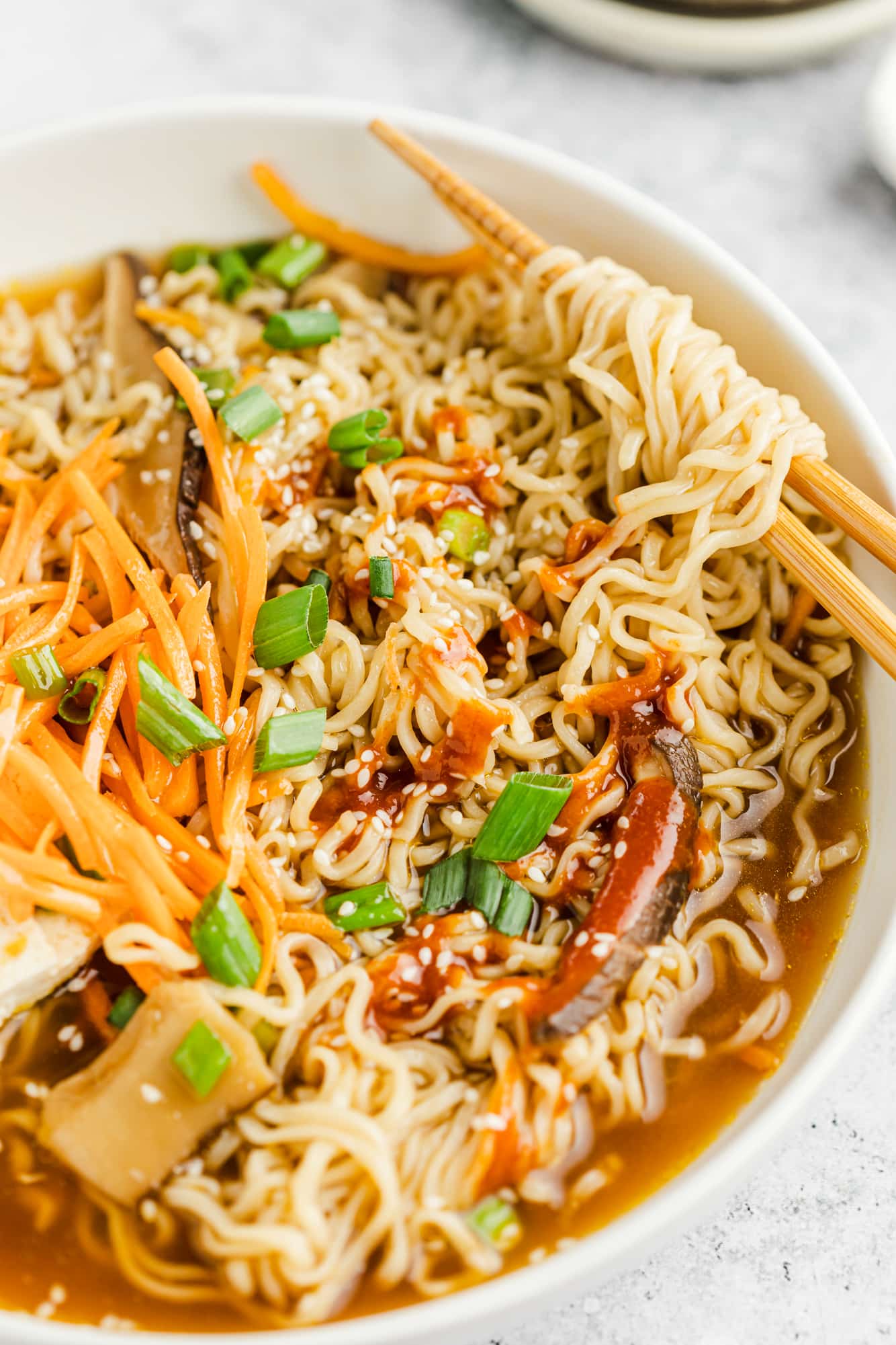 vegan ramen in a large white bowl with chopsticks.