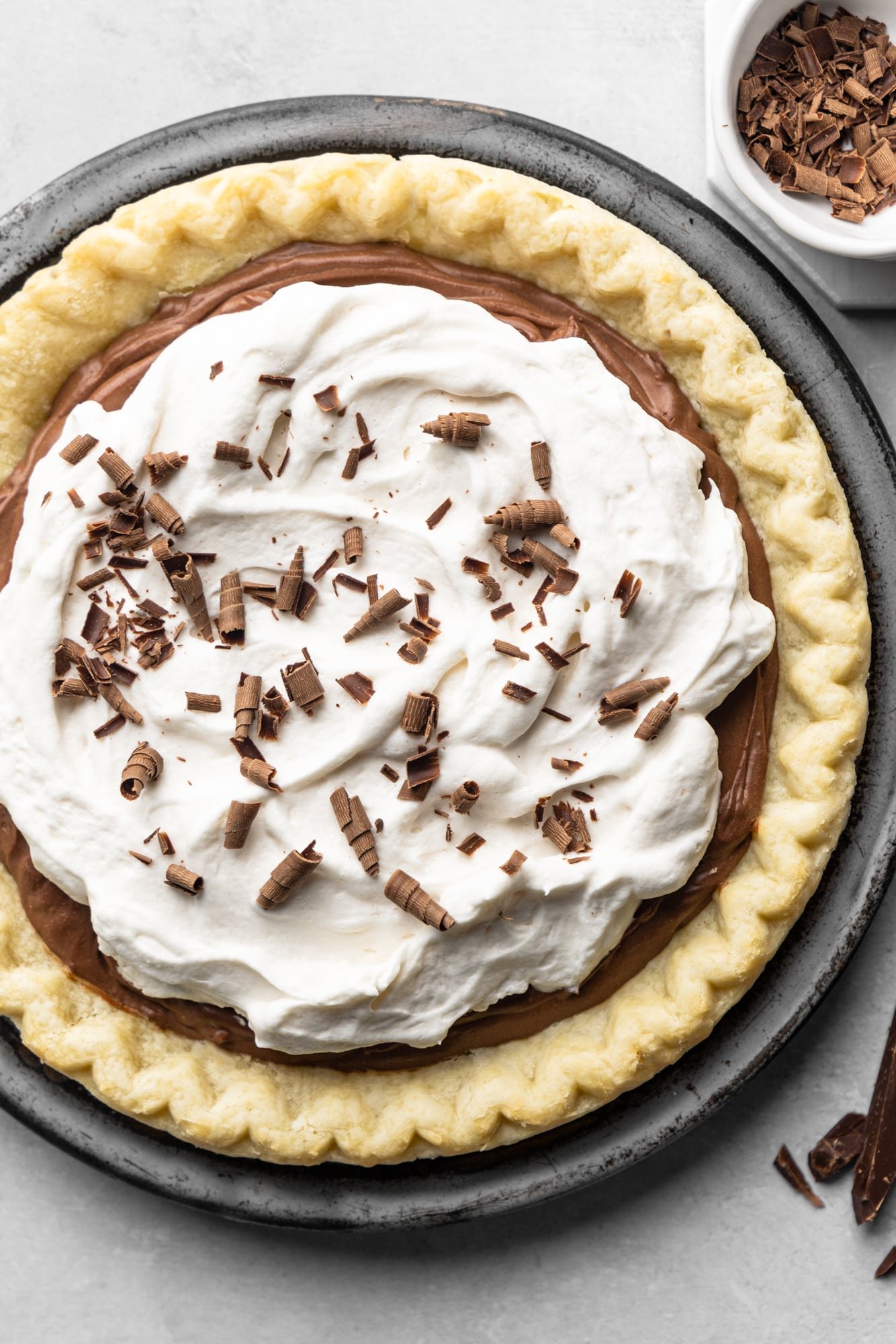 vegan chocolate pie topped with whipped cream and chocolate shavings.