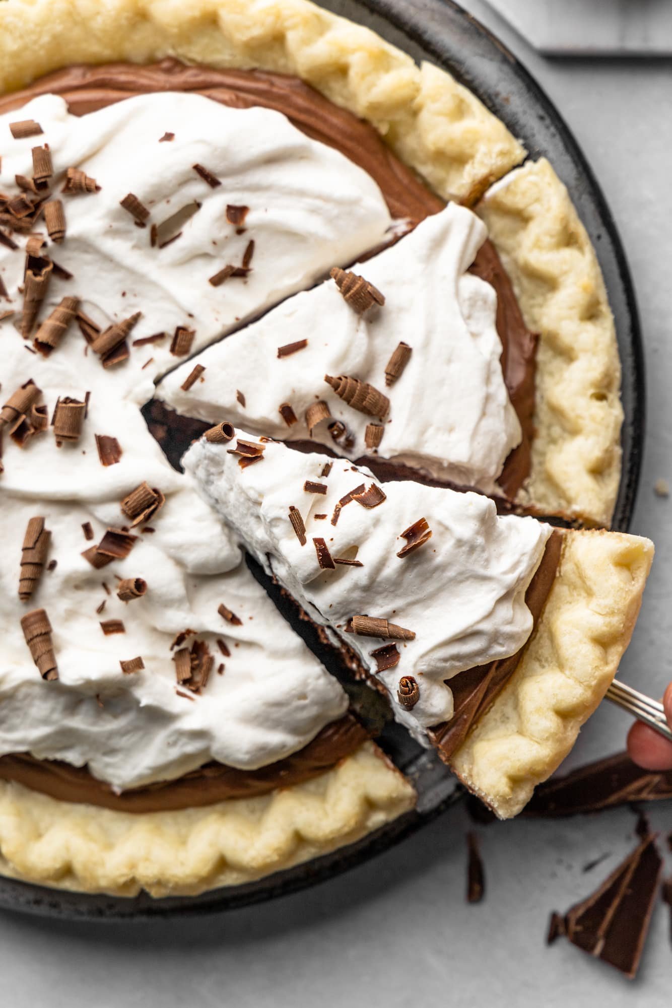 lifting up a slice of vegan chocolate pie from a larger pie.