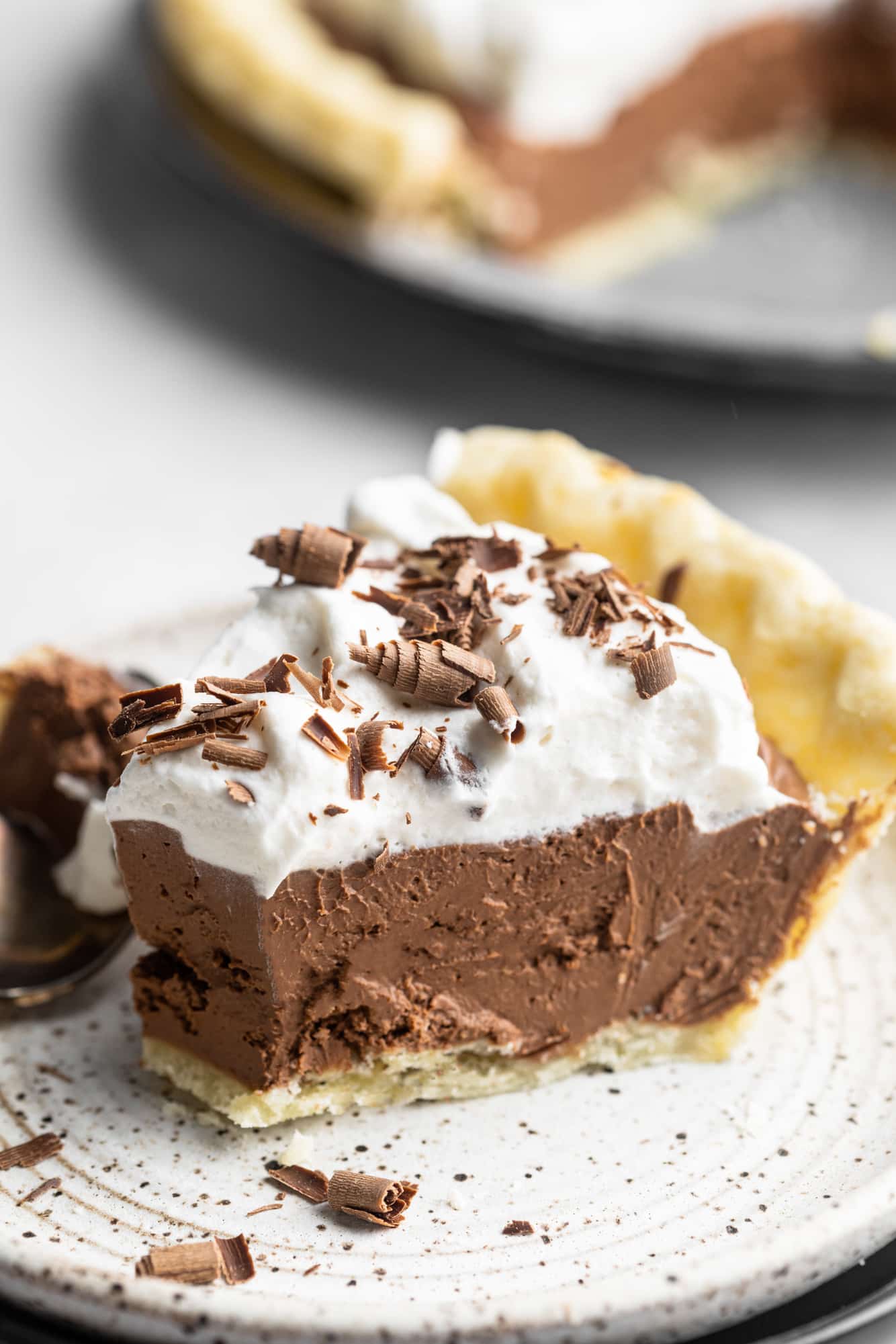 a slice of vegan chocolate pie with a bite removed on a small white plate.