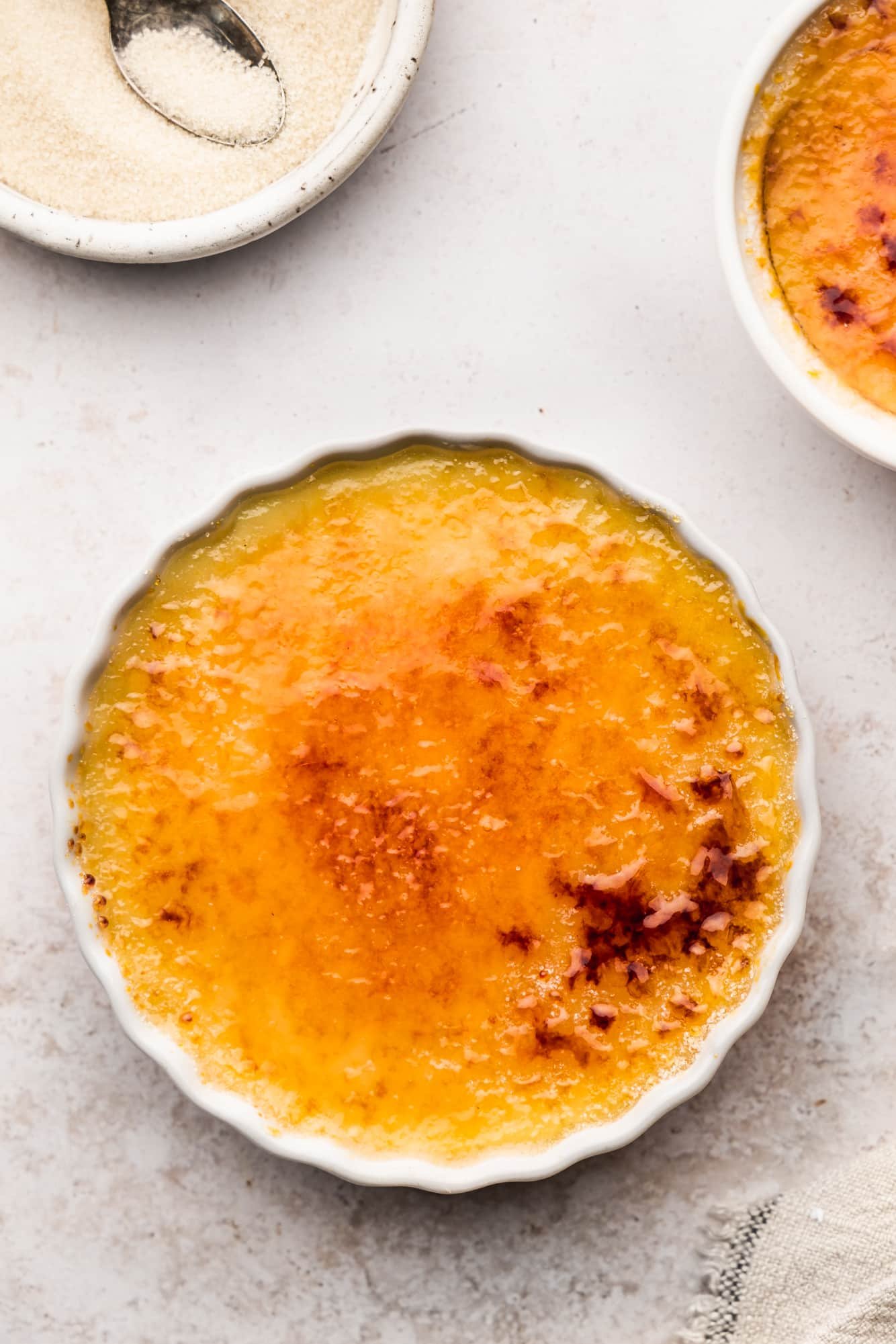 vegan creme brulee with a caramelized sugar topping in a white ramekin.