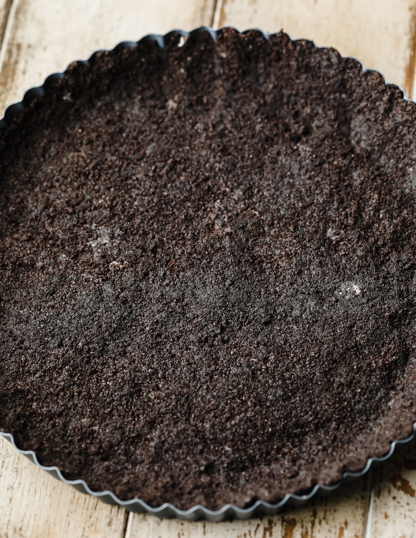 an oreo cookie crust pressed into a tart pan.