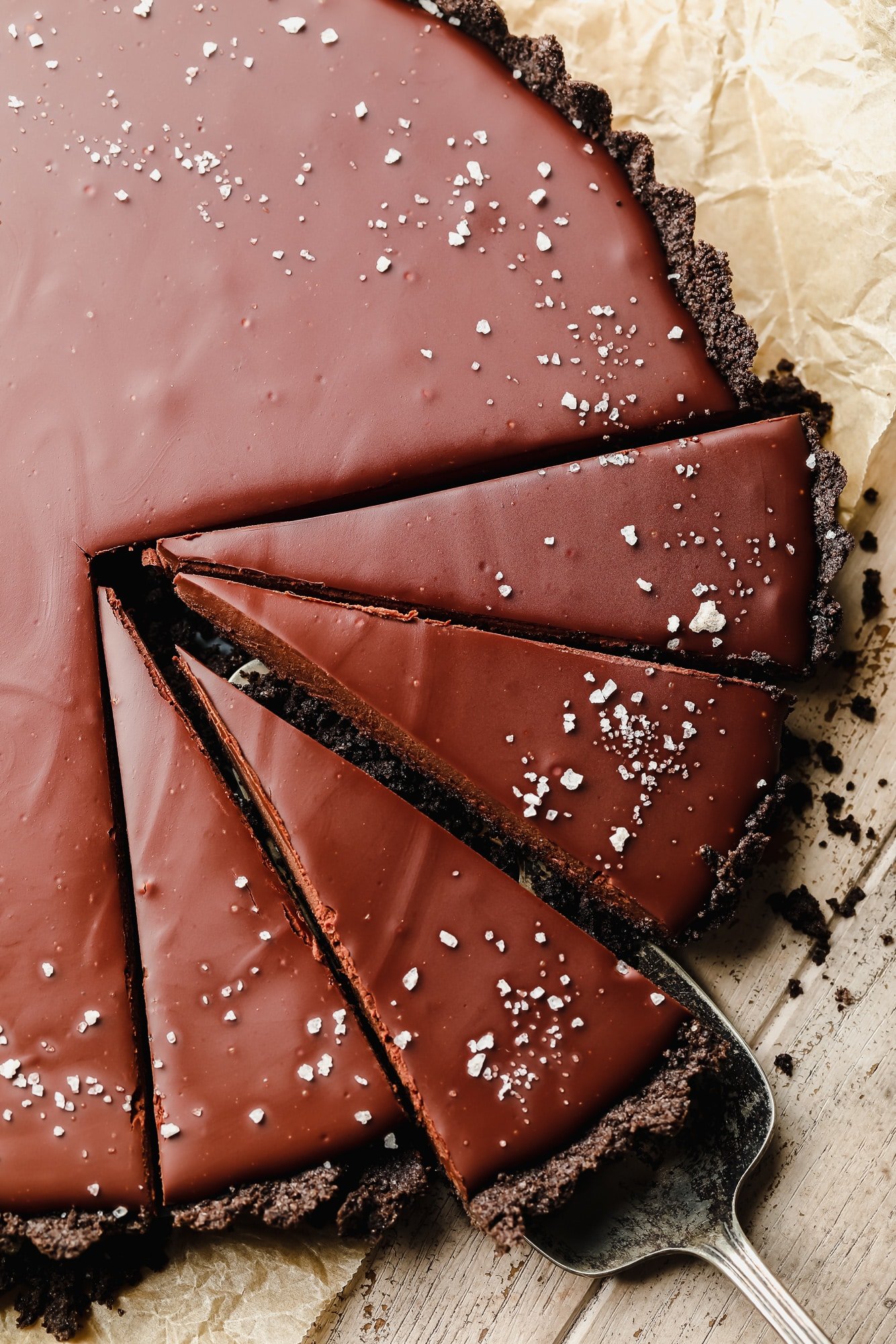 using a cake server to lift up a slice of vegan chocolate tart.