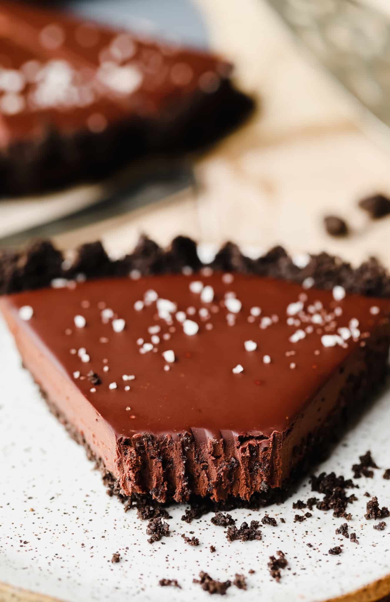 close up on a slice of vegan chocolate tart with a bite missing.