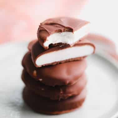 a stack of vegan peppermint patties cut in half on a small plate.