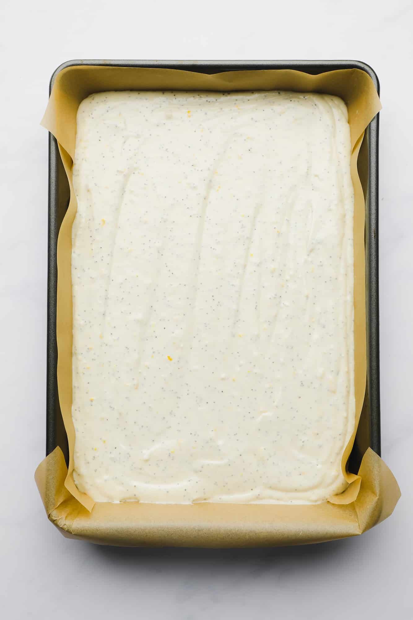 vegan lemon poppyseed cake batter in a large rectangular pan.