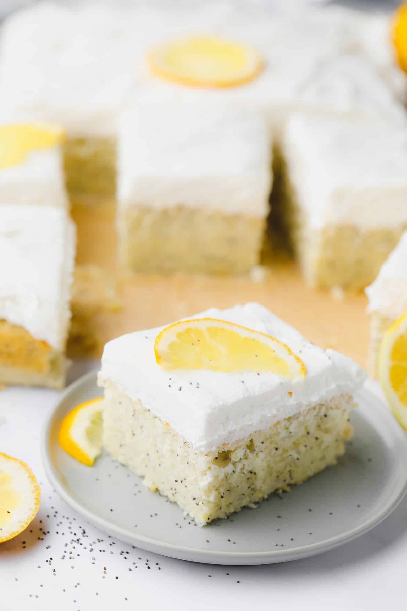 a piece of vegan lemon poppyseed cake on a small grey plate.