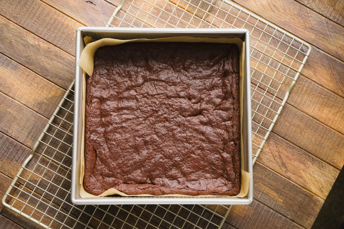 cooked brownies in a pan with a wood background