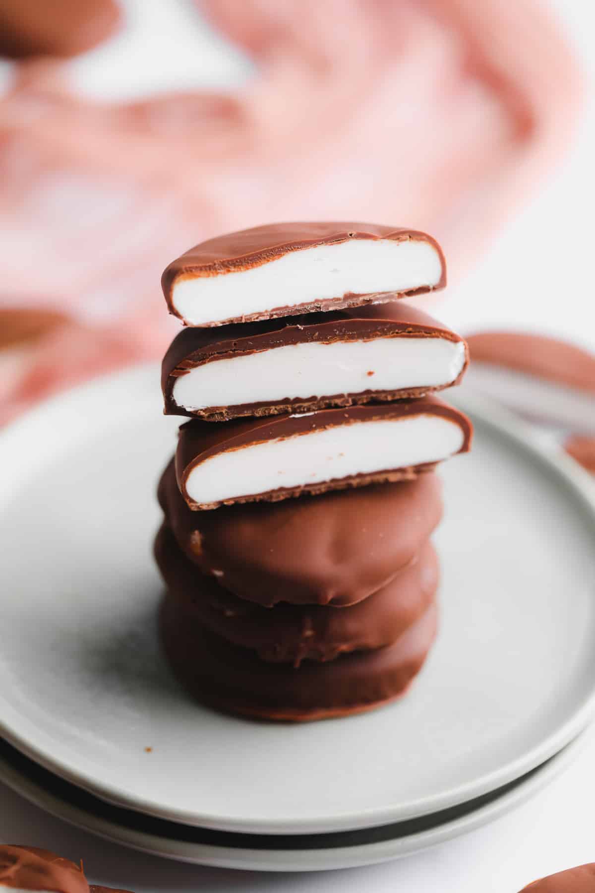 a stack of vegan peppermint patties cut in half on a small plate.