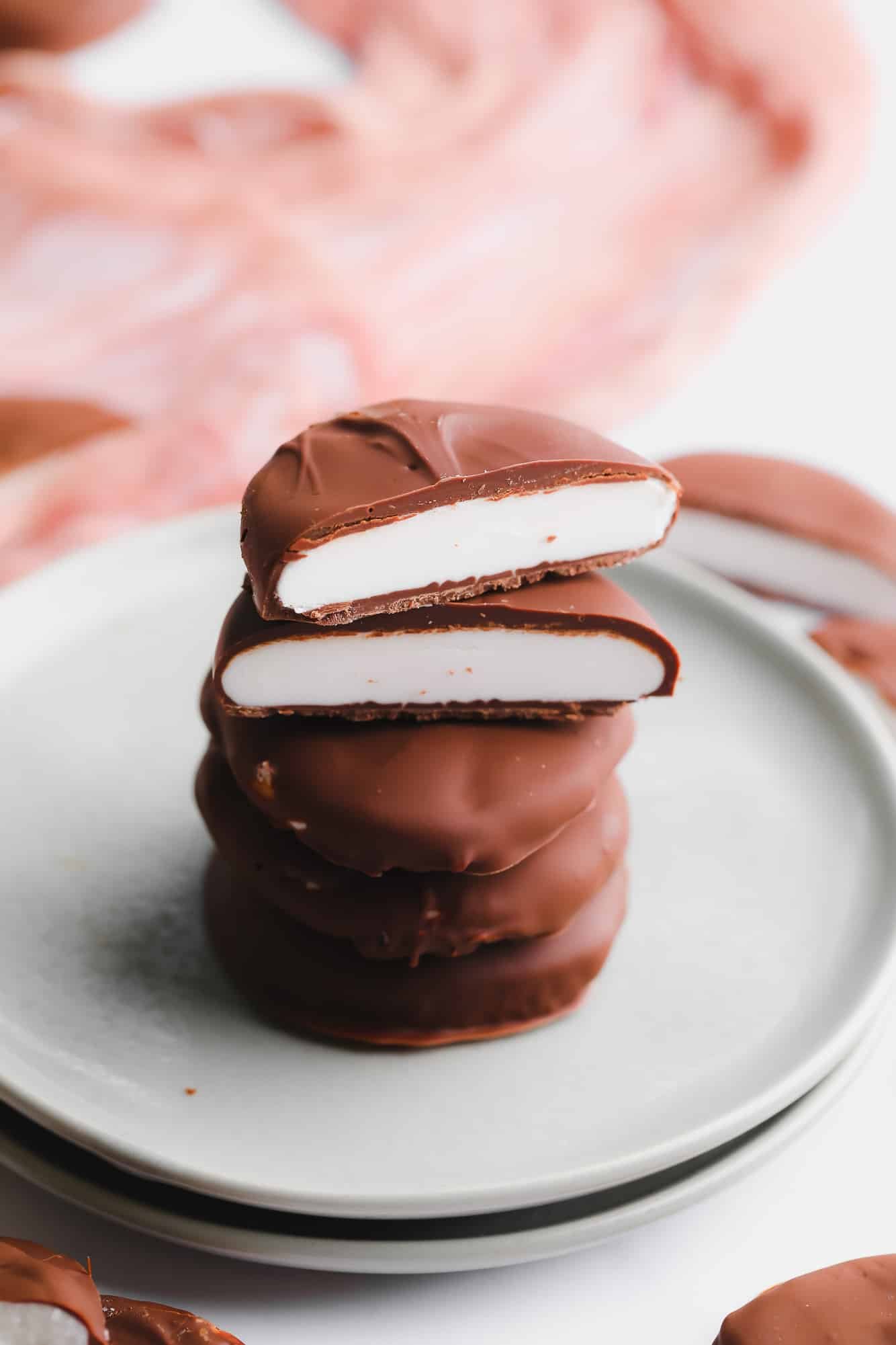 A stack of vegan peppermint patties cut in half on a small plate.