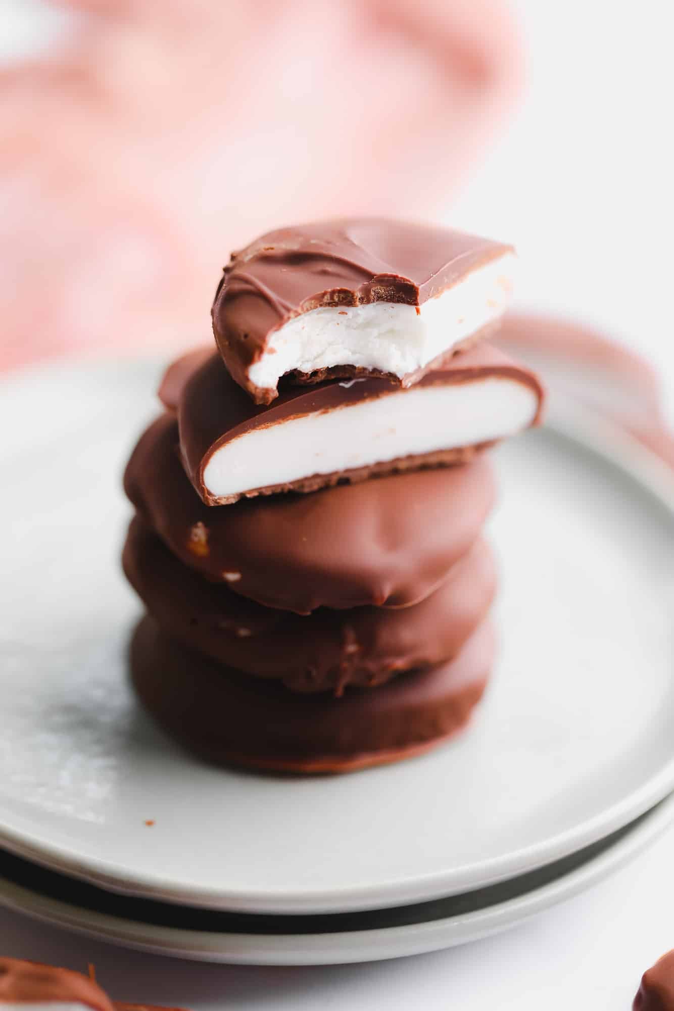 a stack of vegan peppermint patties cut in half on a small plate.