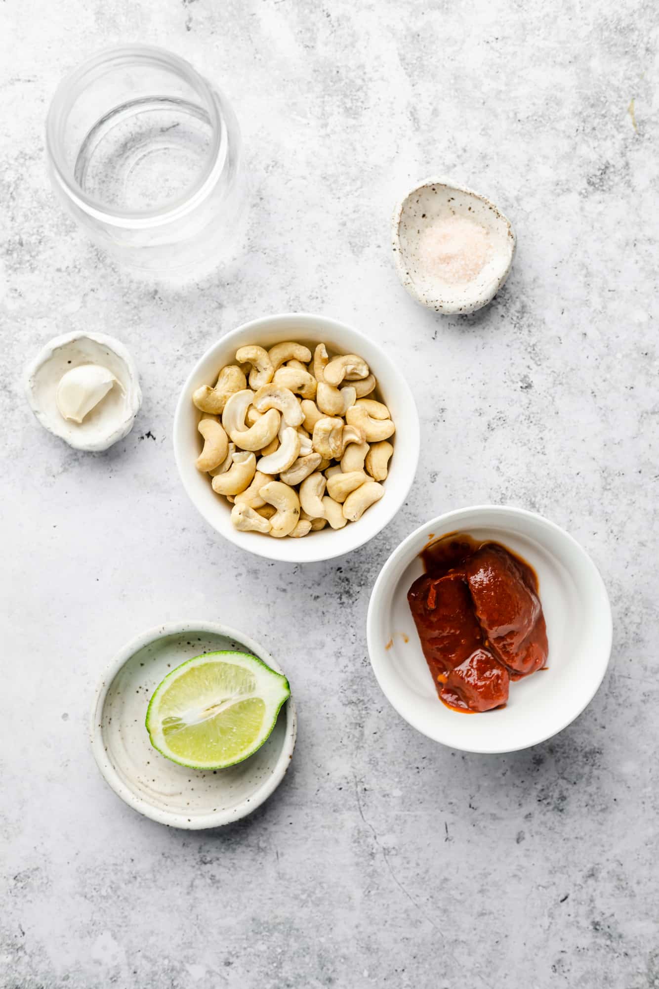Ingredients for chipotle sauce in separate bowls and glasses.